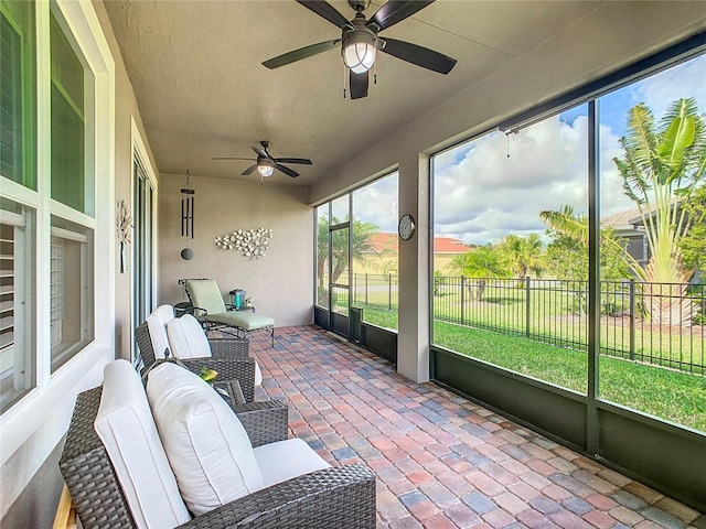 sunroom / solarium featuring ceiling fan