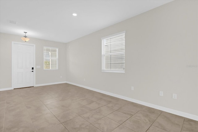 empty room featuring plenty of natural light and light tile patterned floors