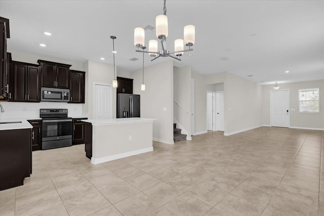 kitchen featuring a center island, an inviting chandelier, pendant lighting, and appliances with stainless steel finishes