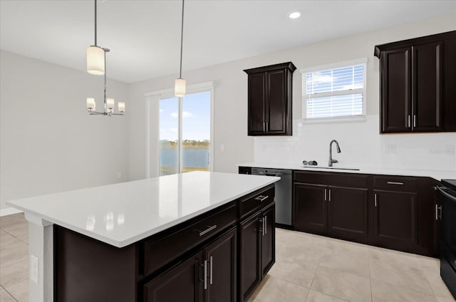 kitchen with dishwasher, sink, hanging light fixtures, a kitchen island, and a chandelier