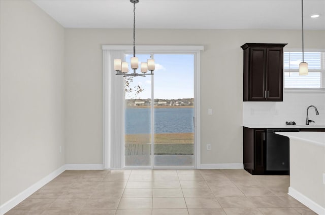 unfurnished dining area featuring light tile patterned flooring, a water view, and a chandelier