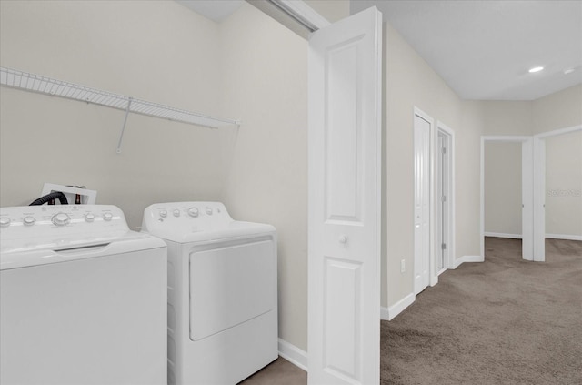 clothes washing area with light carpet and washing machine and clothes dryer