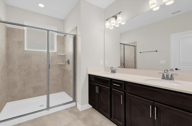 bathroom featuring tile patterned flooring, vanity, and a shower with door