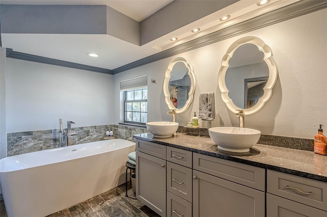 bathroom with vanity, a bathtub, and crown molding