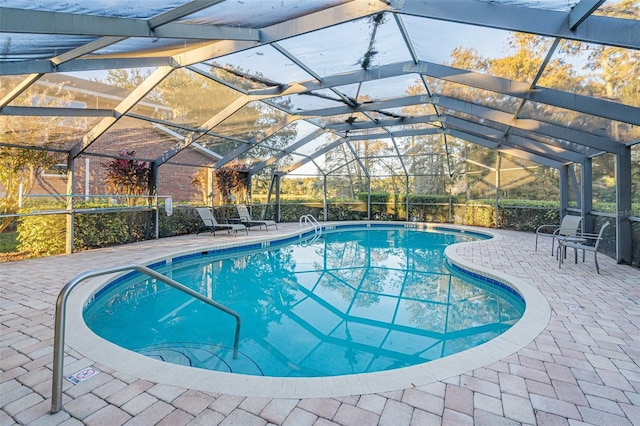 view of pool with glass enclosure and a patio area