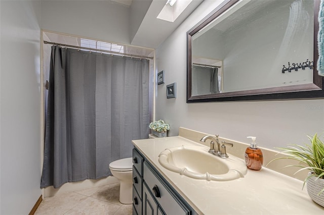 bathroom with toilet, a skylight, a shower with shower curtain, tile patterned flooring, and vanity