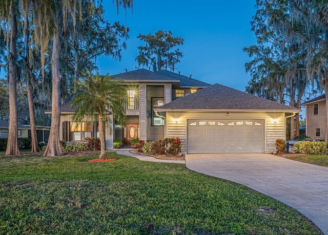 view of front of house featuring a garage and a yard