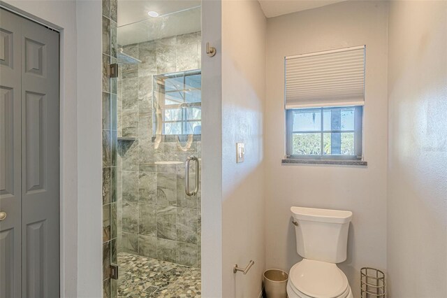 bathroom with toilet and an enclosed shower