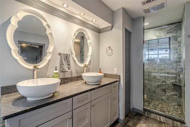 bathroom with a shower with shower door, wood-type flooring, and vanity