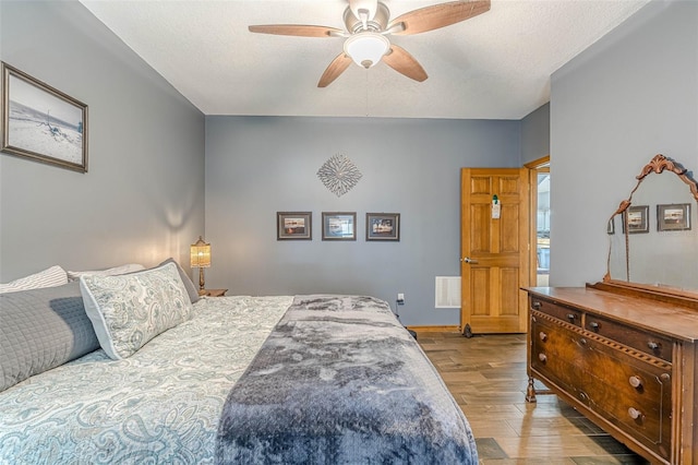 bedroom featuring ceiling fan, light hardwood / wood-style floors, and a textured ceiling