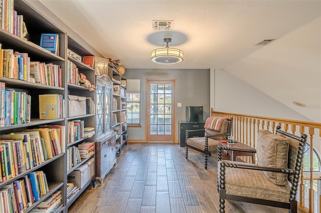 sitting room with vaulted ceiling and hardwood / wood-style flooring