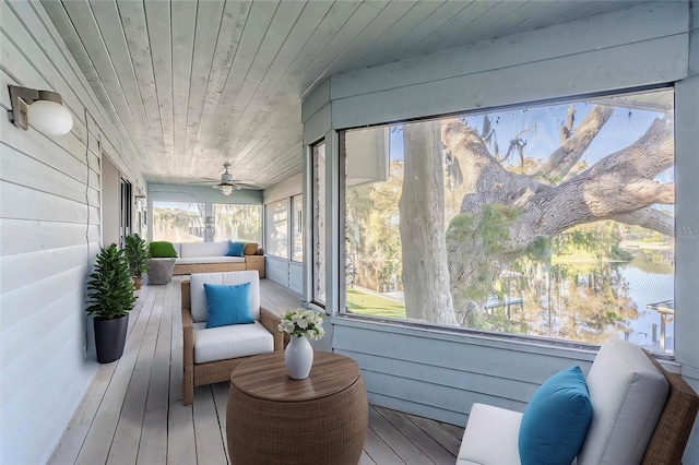 sunroom / solarium featuring a water view, ceiling fan, and wood ceiling