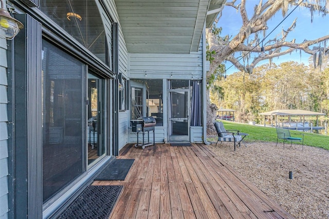 wooden deck with a yard and grilling area