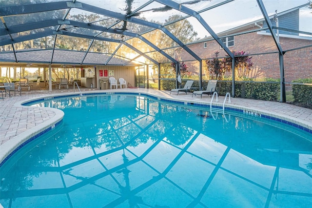 view of pool with a patio area and glass enclosure