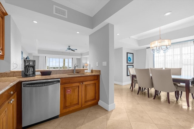 kitchen featuring ceiling fan with notable chandelier, a tray ceiling, sink, dishwasher, and hanging light fixtures