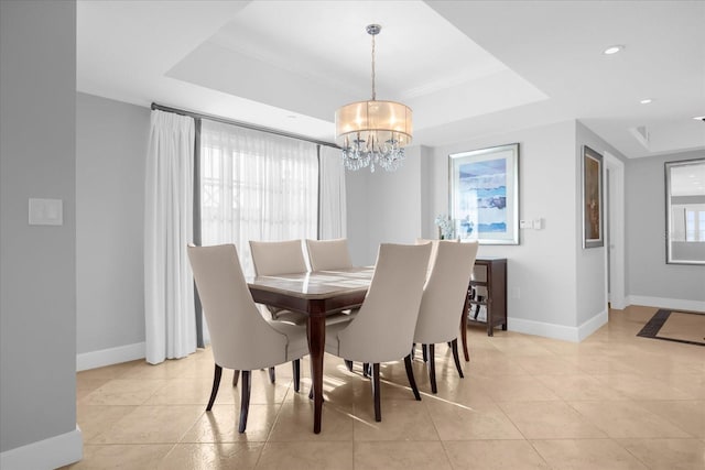 tiled dining room featuring a chandelier and a tray ceiling