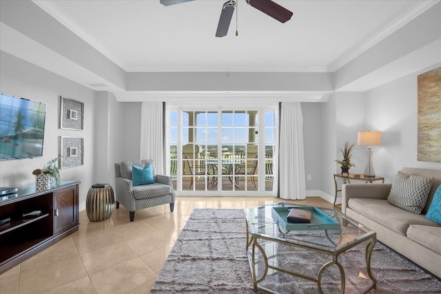 tiled living room featuring a tray ceiling, ceiling fan, and crown molding