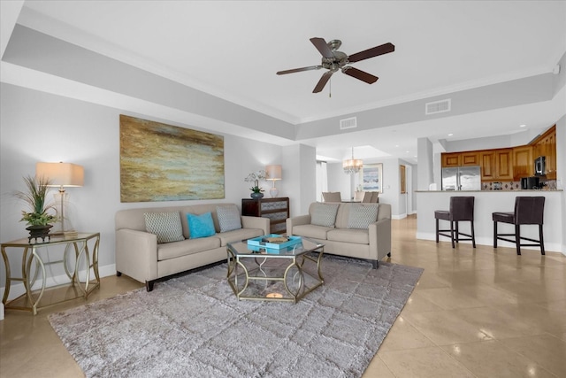 living room featuring ceiling fan with notable chandelier and ornamental molding