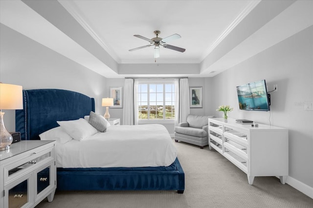 carpeted bedroom featuring a raised ceiling, ceiling fan, and crown molding