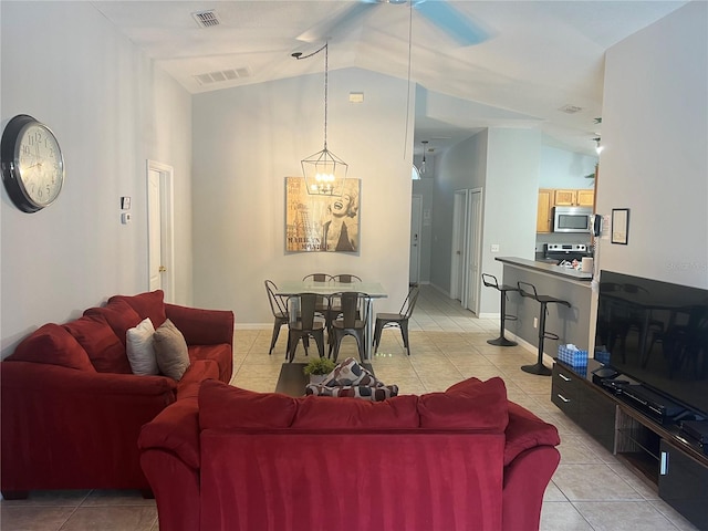 living room featuring light tile patterned floors, lofted ceiling, and a notable chandelier