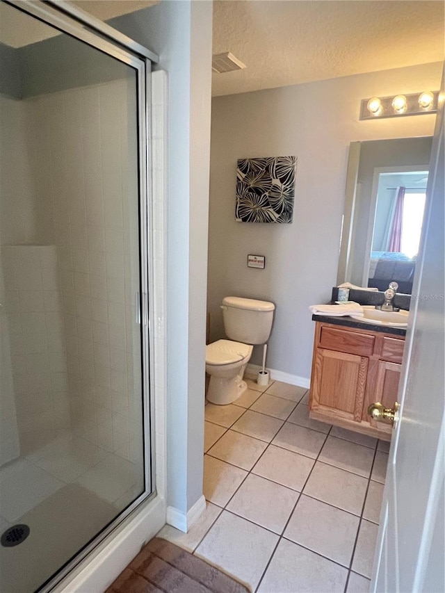 bathroom featuring vanity, tile patterned floors, toilet, a textured ceiling, and a shower with shower door