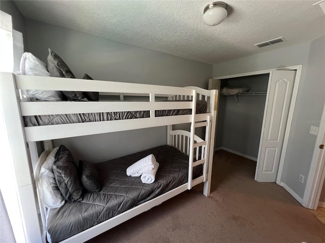 unfurnished bedroom featuring a closet, carpet floors, and a textured ceiling