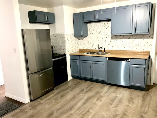 kitchen with light hardwood / wood-style floors, sink, stainless steel appliances, and wooden counters