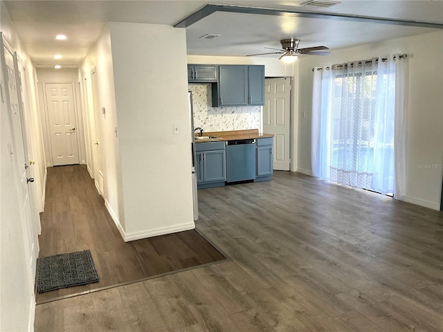 kitchen with stainless steel dishwasher, dark hardwood / wood-style flooring, butcher block counters, and backsplash