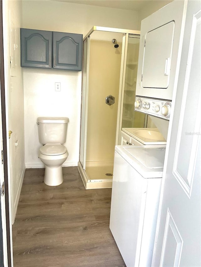 washroom featuring dark hardwood / wood-style floors and stacked washer / drying machine