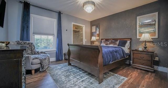 bedroom featuring dark hardwood / wood-style flooring and a chandelier