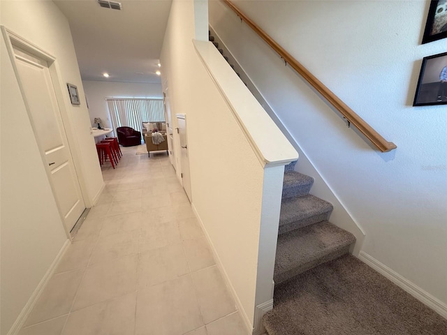 stairway with tile patterned floors