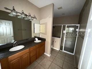 bathroom with tile patterned flooring, vanity, and an enclosed shower