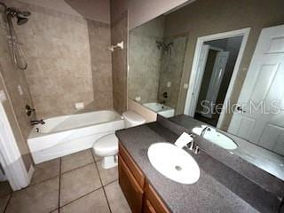 full bathroom with tile patterned floors, vanity, toilet, and tiled shower / bath