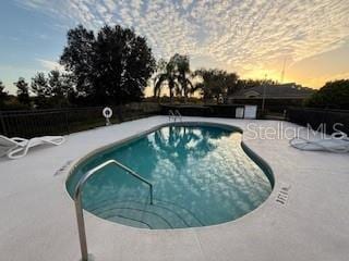 pool at dusk with a patio