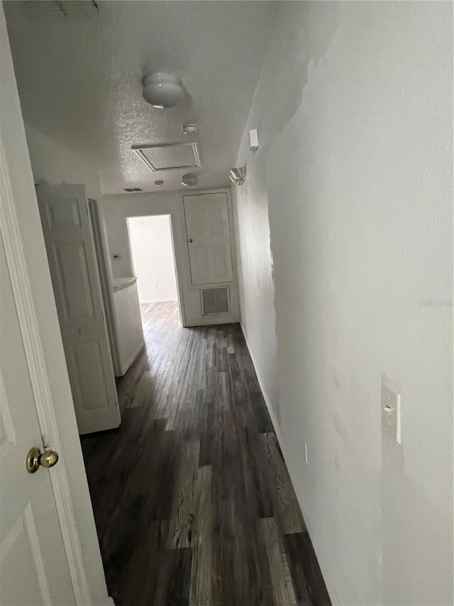 hall featuring a textured ceiling and dark hardwood / wood-style flooring