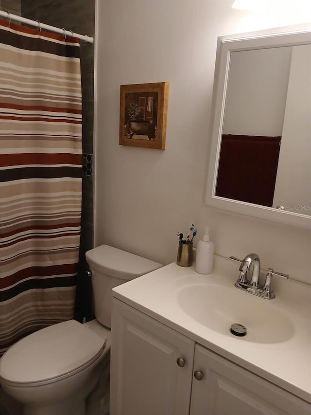 bathroom with vanity, toilet, and curtained shower