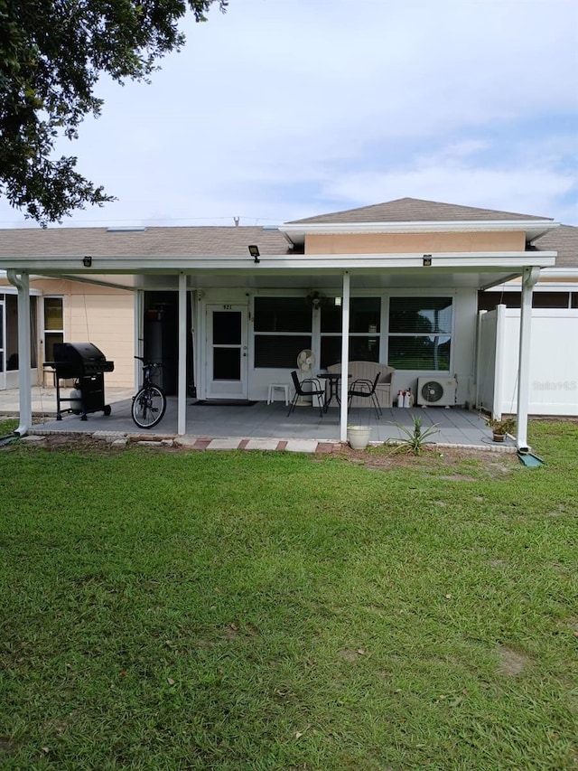 rear view of house with a lawn and a patio