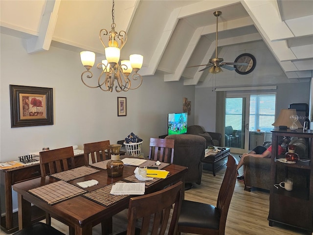 dining area featuring lofted ceiling with beams, wood-type flooring, and ceiling fan with notable chandelier