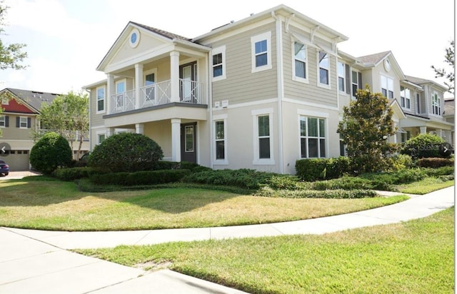 view of front of property featuring a balcony and a front lawn