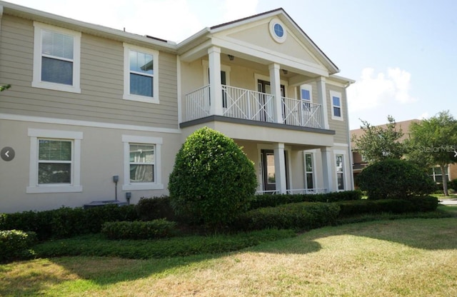 exterior space with a front yard and a balcony