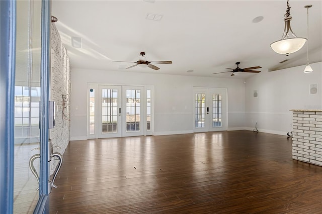 unfurnished living room with dark hardwood / wood-style flooring, ceiling fan, and french doors