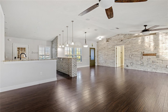 unfurnished living room with ceiling fan, dark wood-type flooring, and vaulted ceiling