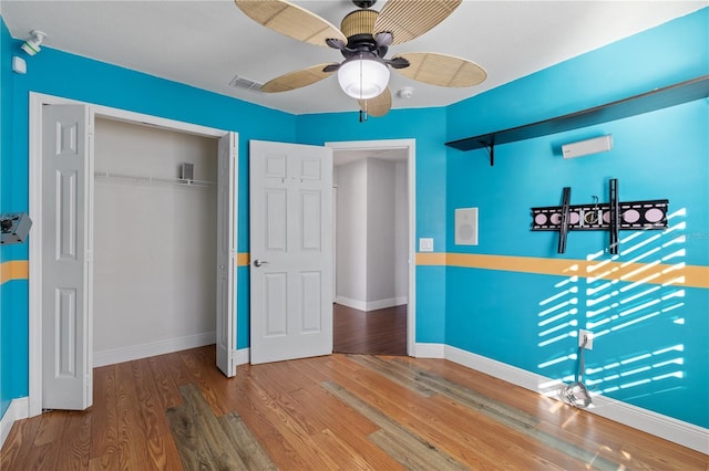 unfurnished bedroom featuring hardwood / wood-style flooring, ceiling fan, and a closet