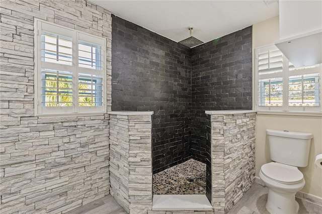 bathroom with a shower, hardwood / wood-style flooring, and toilet