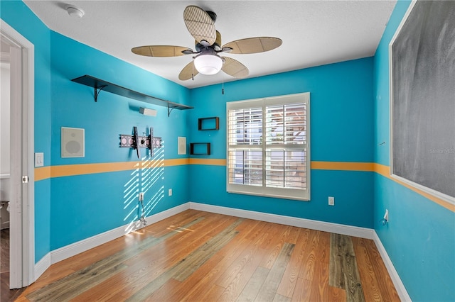 empty room with a textured ceiling, hardwood / wood-style flooring, and ceiling fan