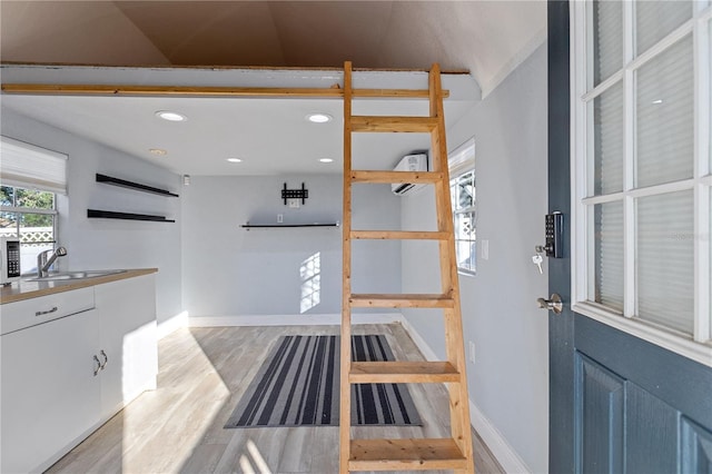 kitchen with sink, light hardwood / wood-style floors, and lofted ceiling