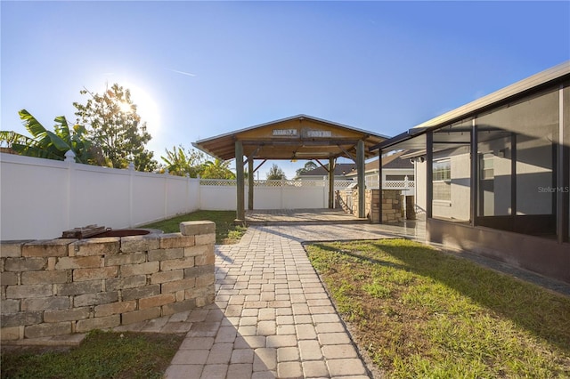 view of yard with a gazebo, a patio area, and a sunroom