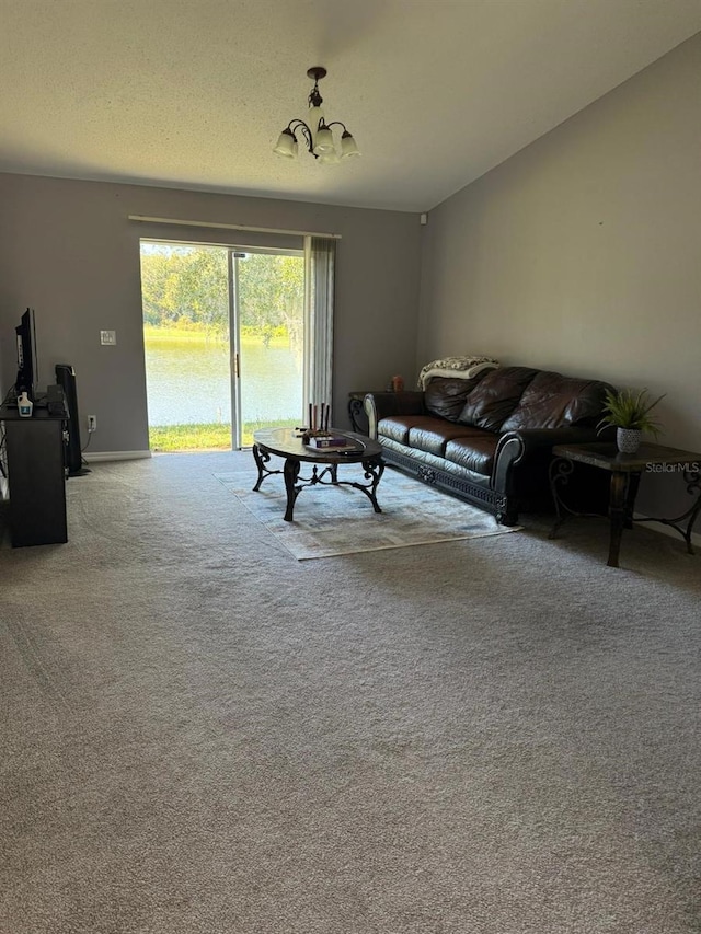 carpeted living room featuring a water view and a notable chandelier