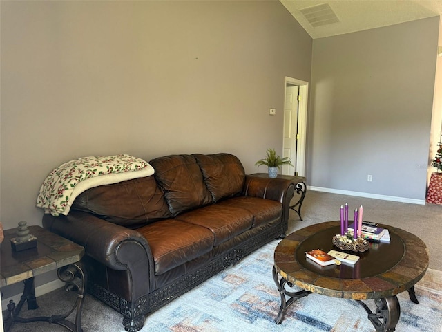 carpeted living room with high vaulted ceiling