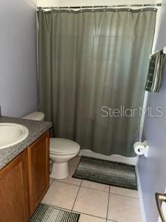 bathroom with tile patterned flooring, vanity, and toilet